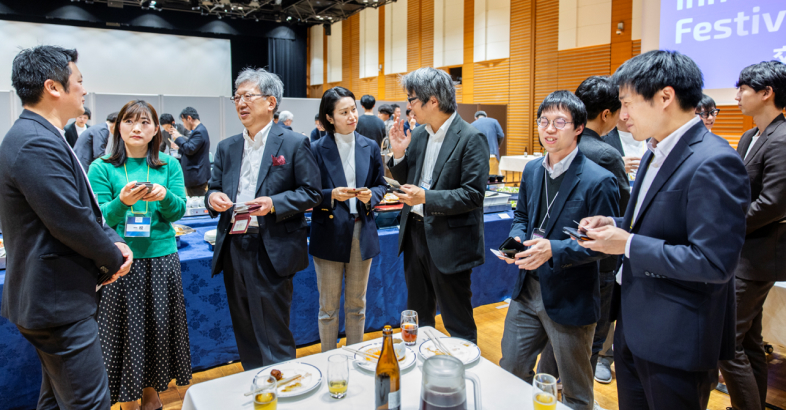 夕方からの交流会が盛況だった。SMBCVCの佐伯社長や（中央左）やレオス・キャピタルワークスの関悠樹氏らが起業家と懇談した。決勝大会でアトツギベンチャー部門賞を獲得したマクライフの牛垣氏（左から2人目）も参加した